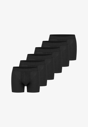 Boxer aderenti in cotone nero con texture a coste, dotati di un elastico in vita e un design aderente. Sei paia sono disposti in fila.