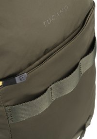 Zaino Tucano in tessuto verde oliva, con chiusura a zip, superficie testurizzata e tasca frontale con dettagli in nylon.