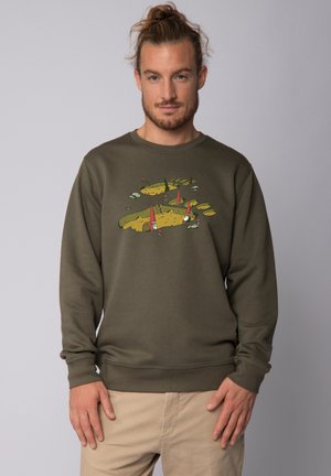 Olive green sweatshirt with a crew neck and ribbed cuffs, featuring a playful illustration of gnomes and landscapes on the front.