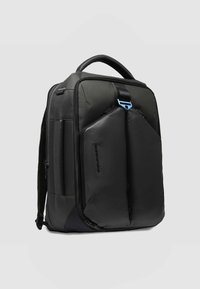 Zwarte rugzak met een gestructureerde stof en gladde matte accenten. Voorzien van een dubbel ritssluiting voorvak en een stevige bovenste handgreep.