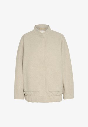 Beżowa, strukturalna kurtka z wysokim kołnierzem, opadającymi ramionami i dwiema przednimi kieszeniami. Elastyczny dół i czysty, minimalistyczny design.