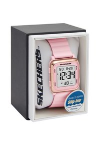Reloj digital con una correa de silicona rosa y una esfera cuadrada en tono dorado. Las características incluyen una pantalla digital, múltiples botones y acentos de logotipo.