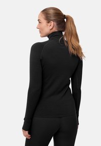 Svart långärmad tröja med hög hals och figursydd design, slät textur och synliga sömdetaljer, kombinerad med matchande svarta underdelar.