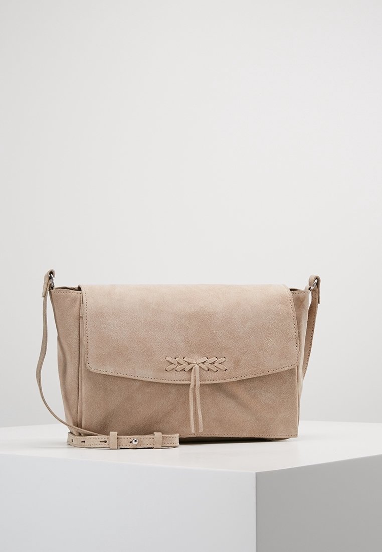 Béžová semišová crossbody taška s klopou, dekorativním pletením a nastavitelným popruhem, s hladkým povrchem a obdélníkovým tvarem.