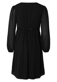 Schwarzes Kleid mit langen, durchsichtigen Ärmeln, tailliertem Bund und Schleifendetail auf der Rückseite. Weicher Stoff und lockere Passform mit einem knielangen Saum.