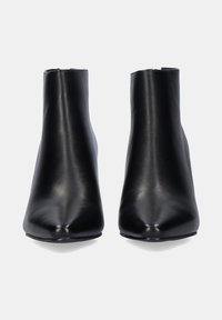 Botas de tobillo de cuero negro con un diseño de punta afilada, textura suave y una silueta elegante, que cuentan con un tacón bloque de altura media.