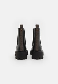 Black leather ankle boots featuring a textured brown patterned panel at the back, with a chunky black sole and pull tabs for easy wear.