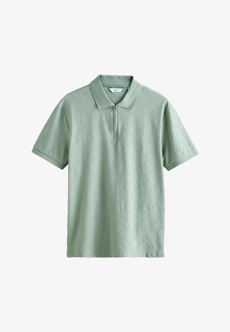 Polo manches courtes vert clair avec motif en vague texturé et fermeture éclair devant sous le col.