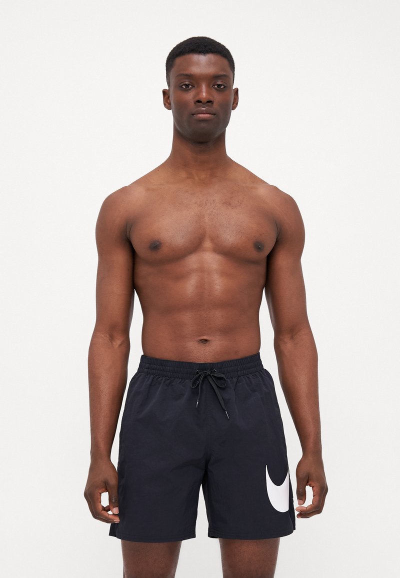 Costume da bagno nero con vita a cordoncino, caratterizzato da un grande logo Nike swoosh bianco sul lato sinistro inferiore. Tessuto dalla superficie liscia.