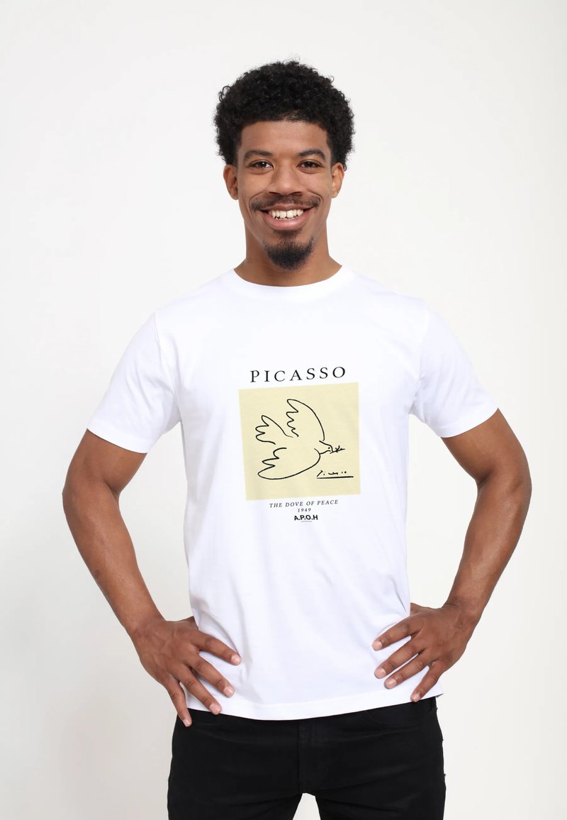 Bílý bavlněný tričko s designem od Picassa, na kterém je holub na žlutém čtverci, s textem pod ním: "HOLUBICE MÍRU 1949 A.P.O.H."