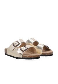 Sandales à glissière métalliques dorées avec deux boucles réglables, semelle en liège et semelle en caoutchouc noire ; design minimaliste, style ouvert.