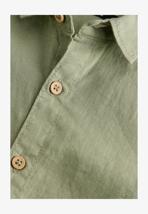 Lichtgroene linnen shirt, voorzien van een kraag en drie knoopsluitingen met een houten structuur. Gladde stof met een subtiele glans.