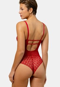 Body en lingerie rouge avec un dos en dentelle, des bretelles fines et réglables, et un design découpé au bas du dos. Texture douce, coupe ajustée.