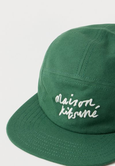 Πράσινο υφασμάτινο καπέλο με κυρτή γείσο, κεντημένο με λευκό καλλιγραφικό κείμενο «maison kitsuné» στον μπροστινό πίνακα.