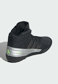 Black high-top athletic shoe with textured fabric upper, three black stripes, silver midsole, and green "SPEEDDEX" accent on heel.