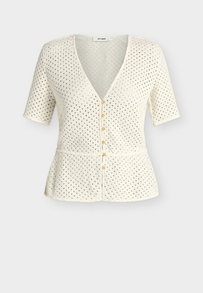 Πλεκτή ζακέτα σε κρεμ απόχρωση με κοντά μανίκια, V-λαιμόκοψη, κουμπιά μπροστά, μικρό σχέδιο με οπές και εφαρμοστή μέση.