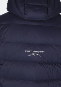 Mörkblå vadderad jacka med huva, som har quiltade sektioner och en vit "SWEDEMOUNT™"-logotyp ovanför en bergsgrafik på baksidan.