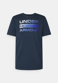 Mørkeblå t-skjorte med kort erme laget av mykt materiale, med "UNDER ARMOUR" trykt i gradientnyanser fra blå til hvit over brystet.