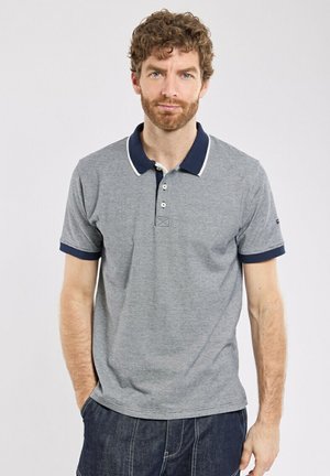 Polo gris avec col et poignets navy, comportant deux boutons et un tissu texturé. Inclut un logo brodé sur la manche.