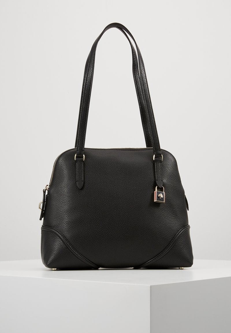 Sort læderhåndtaske med tekstureret finish, dobbelte håndtag, guldfarvet beslag, lynlåslukning og en lille vedhæng fastgjort på siden.