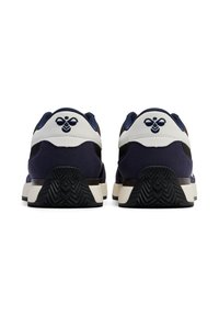Marineblå og hvide sneakers med en tekstureret overdel, der har en gummisål, afrundet form og prægede logo på hælen.