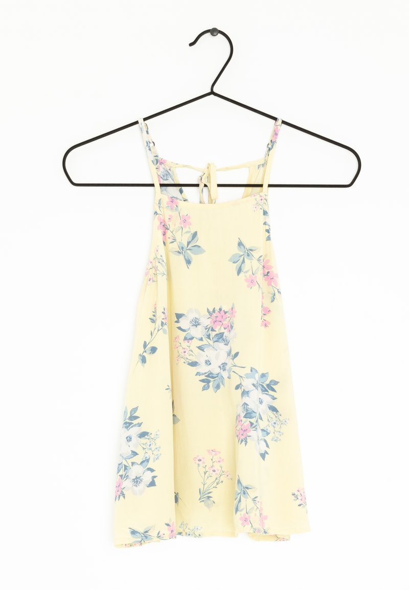 Sukienka w kwiaty w jasnożółtym kolorze, wykonana z materiału, z wielokolorowymi wzorami kwiatowymi, regulowanymi ramiączkami i wiązaniem z tyłu. Idealna na ciepłe dni.