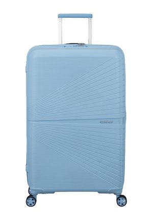 Grande valigia rigida azzurro chiaro con maniglia telescopica e quattro ruote rotanti a 360 gradi, caratterizzata da un design a linee diagonali testurizzate.