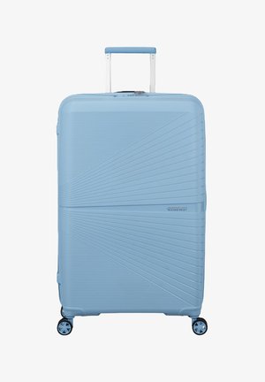 Grande valigia rigida azzurro chiaro con maniglia telescopica e quattro ruote rotanti a 360 gradi, caratterizzata da un design a linee diagonali testurizzate.