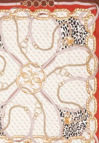 Scarf di seta con un motivo floreale, catene dorate, lacci rosa chiaro e una sezione a stampa leopardata, su uno sfondo rosso.