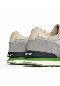 Sneaker grigie in suede e mesh con un retro in pelle beige, dettagli verdi e una suola intermedia blu navy con marchi bianchi.