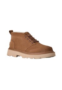 Botín de ante marrón con cordones en la parte delantera y suela de goma beige gruesa, diseñado para uso casual.