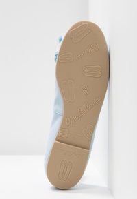 Ballerines bleues avec une tige douce et lisse et une semelle en caoutchouc beige texturée. Dotées d'un logo imprimé et de motifs de chaussons de ballet sur la semelle.