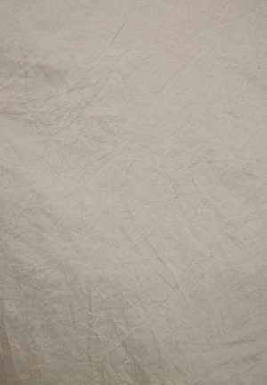 Light beige textured fabric with noticeable wrinkles and a soft, matte finish. The surface appears slightly uneven, indicating natural fibers.