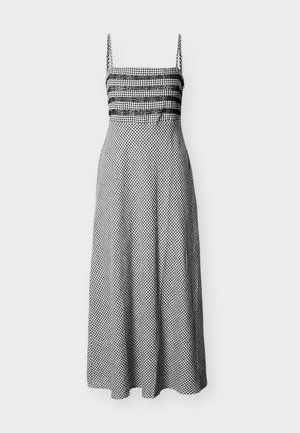 Abito midi a quadretti bianco e nero con spalline sottili, dettaglio in pizzo sul seno e vita aderente con gonna svasata.