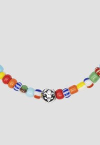 Farverig perlekæde med multicolore rund perler i blå, rød, gul og grøn, med en central sølvblomst som accent.