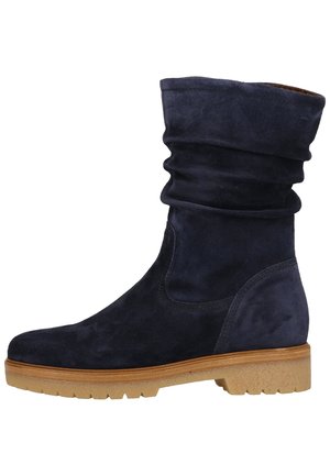 Marineblauwe suède laars tot halverwege de kuit met een lichtbruine rubberen zool en een lage, brede hak, ontworpen voor dagelijks gebruik.