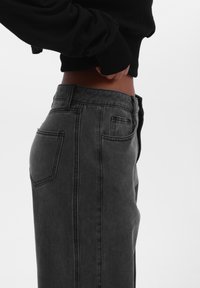Høj talje, sorte denim jeans med en slank pasform. Funktioner inkluderer to baglommer og en klassisk lynlås lukning.