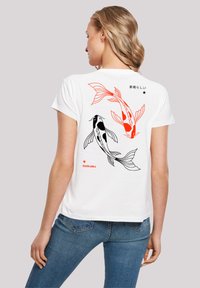 White t-shirt featuring black and red koi fish illustrations on the back, with Japanese text and a star accent. Short sleeves, relaxed fit.