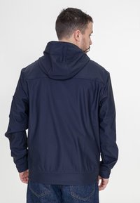 Granatowa kurtka z kapturem, wykonana z lekkiego, gładkiego materiału. Posiada szew z przodu, elastyczne mankiety i regulowany kaptur ze sznurkiem.