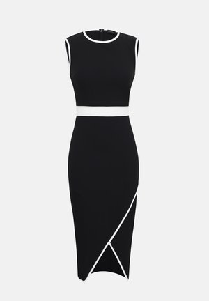 Abito midi nero senza maniche con bordo bianco sul collo, sugli spacchi delle maniche, in vita e su uno spacco frontale inclinato della gonna, su sfondo semplice.