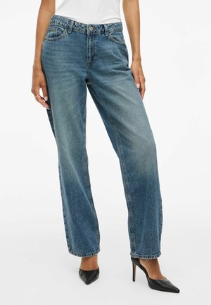 Jean en denim bleu clair, à taille haute et jambes larges, avec poches avant et fermeture à bouton, présentant une finition délavée et des coutures visibles.