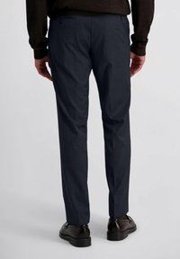 Op maat gemaakte donkerblauwe broek van zachte stof, met een slim fit, rechte pijpen, twee achterzakken met knopen en subtiele plooien.