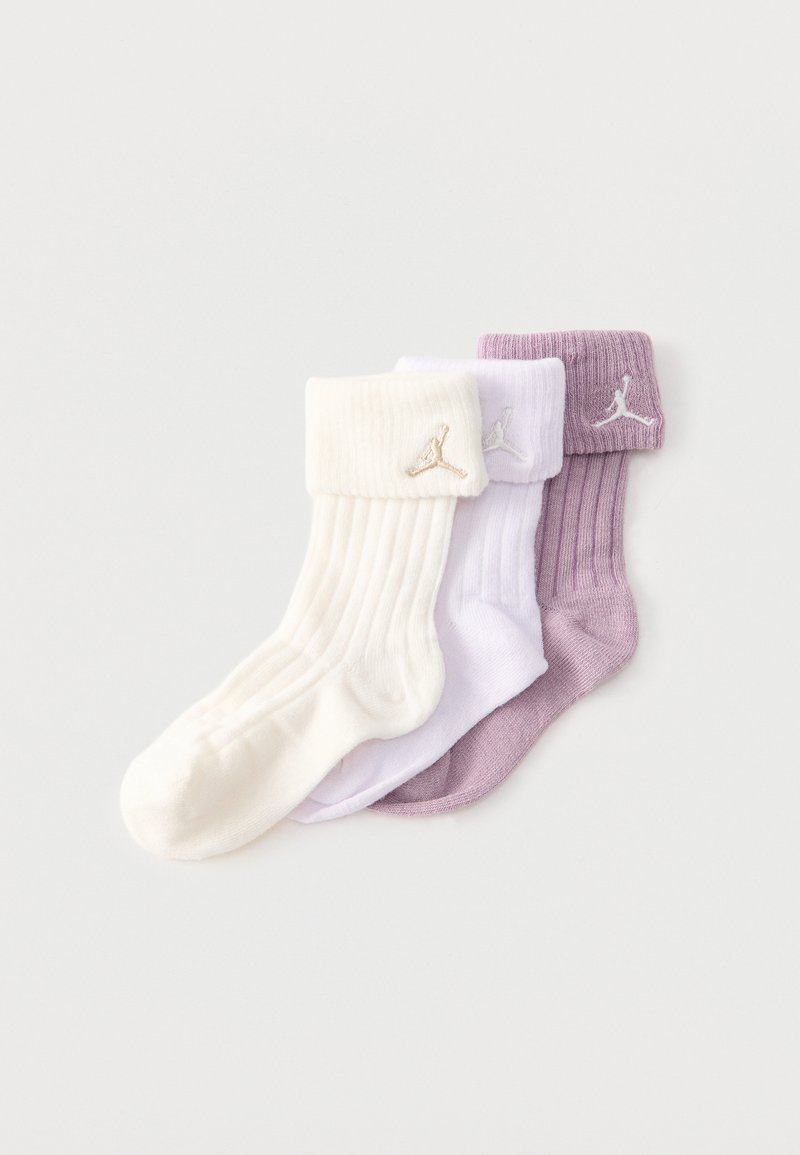 Τρεις διπλωμένες ριμπ κάλτσες κοντά στον αστράγαλο σε κρεμ, λευκό και μοβ, καθεμία με ένα μικρό κεντητό λογότυπο κοντά στον ρεβέρ.