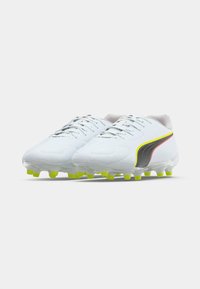 White soccer cleats with a smooth synthetic upper, accented by yellow and red details, and a clear sole with yellow studs for traction.