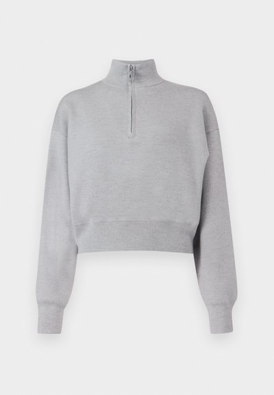 Világosszürke, rövidített pulóver magas nyakkal, félig cipzárral és hosszú ujjal. Puha tapintású, alján bordás szegéllyel.