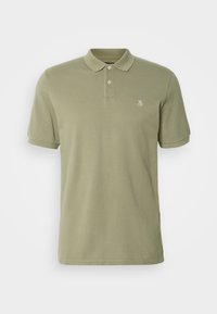 Polo à manches courtes de couleur olive avec deux boutons et un petit logo blanc sur la poitrine gauche, présenté sur un fond uni.