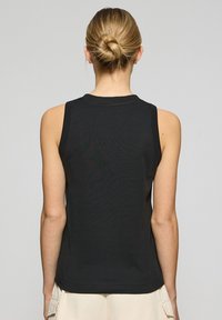 Czarny top bez rękawów z okrągłym dekoltem i gładką, bawełnianą teksturą; posiada prosty dół i brak widocznych elementów metalowych.