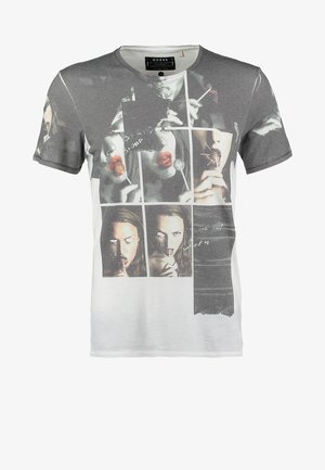 T-shirt met zwart-witte collage van een vrouw die een lolly vasthoudt en likt, rode lippen en handgeschreven tekstdetails.