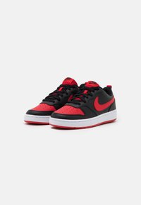 Black and red sneakers with a smooth leather upper, perforated toe box, padded collar, white midsole, and red rubber outsole. Nike logo visible.