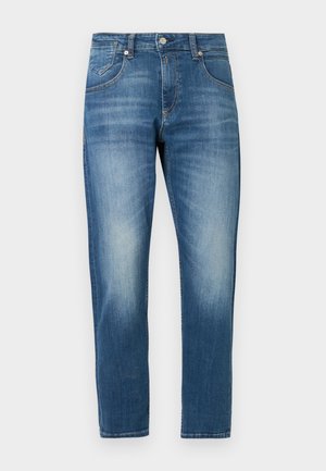 Blå denimjeans med rett ben, middels vask og subtil falming. Har fem lommer, beltestropper og sølvfargede knapper.